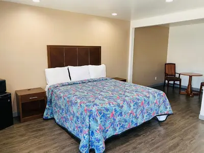 a bedroom with a large bed with a blue blanket at Cozy motel in Lynwood