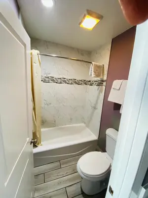 a bathroom with a toilet and a bath tub at Cozy motel in Lynwood