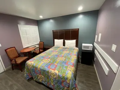 a hotel room with a bed and a table and chair at Cozy motel in Lynwood