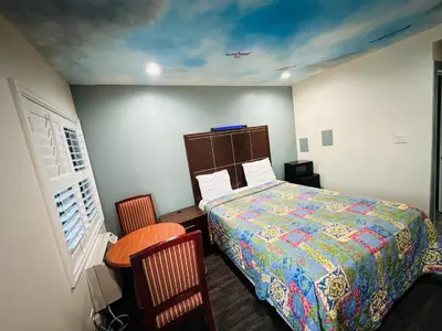 a bedroom with a bed and a table and chairs at Cozy motel in Lynwood