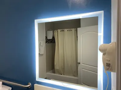 a mirror in a bathroom with a shower curtain at Cozy motel in Lynwood