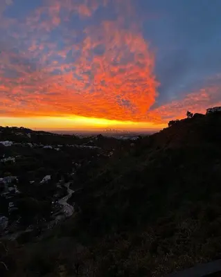 a sunset on a hill with the sun setting at HOLLYWOOD HILLS JETLINER VIEWS at STUDIO 1080 HOLLYWOOD in Los Angeles