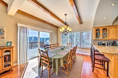 a dining room with a table and chairs and a large window at Mountain Gem with Game Room, 5 Mi to Lake Arrowhead! in Lake Arrowhead