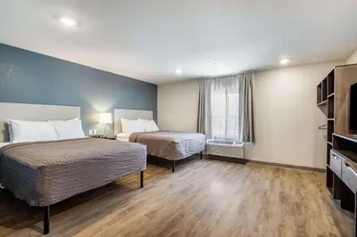 a hotel room with two beds and a window at WoodSpring Suites Colton in Colton