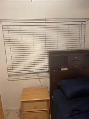 a bedroom with a bed and a window with blinds at Home Sweet Home in Colton