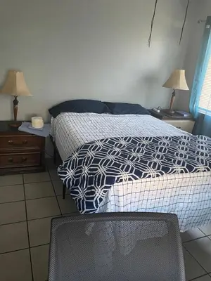 a bedroom with a bed and two night stands with lamps at Home Sweet Home in Colton