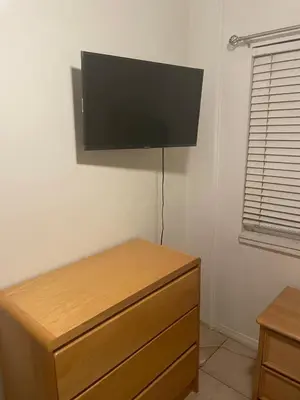 a flat screen tv hanging on a wall above a dresser at Home Sweet Home in Colton