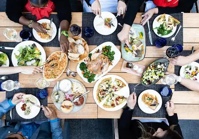 a group of people sitting around a table eating food at Luskin Hotel in Los Angeles