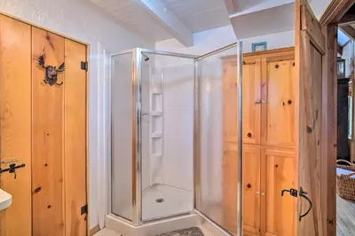 a shower in a bathroom with wooden cabinets at Lakeview Lodge Fit for Groups Less Than 1 Mile to Lake! in Lake Arrowhead