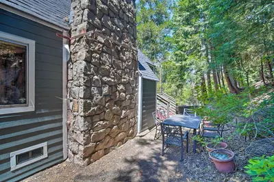 a stone house with a table and chairs next to a building at Lakeview Lodge Fit for Groups Less Than 1 Mile to Lake! in Lake Arrowhead
