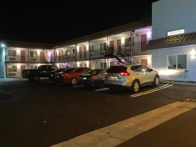 a group of cars parked in a parking lot in front of a building at PASADENA LODGE in Pasadena