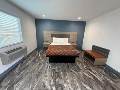 a bedroom with a bed and a large window at Travel Inn Motel in Anaheim