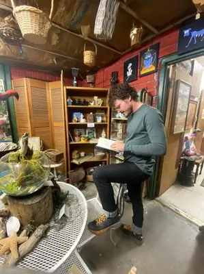 a man sitting on a chair reading a book at SoCal Camping in Kernville