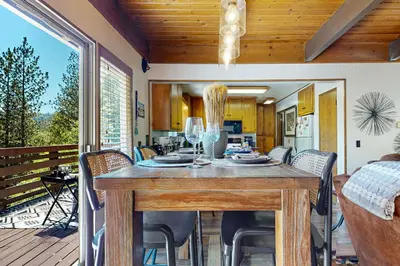 a dining room with a table and chairs on a deck at House of the Rising Sun in Lake Arrowhead