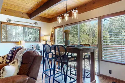 a living room with a dining room table and chairs at House of the Rising Sun in Lake Arrowhead