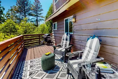 two chairs and a table on a deck at House of the Rising Sun in Lake Arrowhead