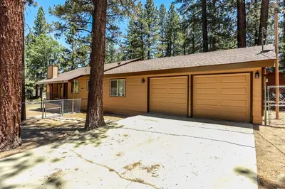 a house with two garage doors and trees at Bohemia Big Bear-1926 by Big Bear Vacations in Big Bear Lake