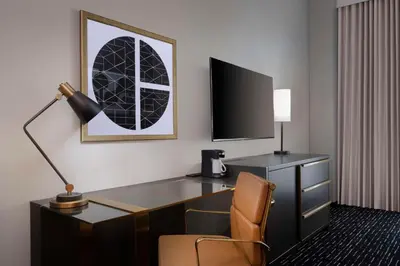 a hotel room with a desk with a lamp and a chair at Hyatt House LAX Century Blvd in Los Angeles