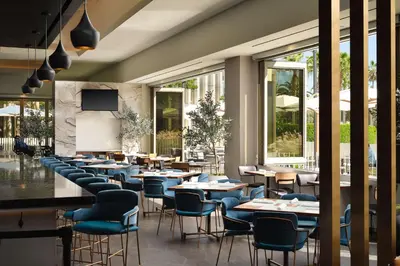 a restaurant with tables and chairs and windows at Hyatt Place LAX/Century BLVD in Los Angeles