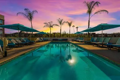 a pool with chairs and umbrellas at a hotel at Residence Inn by Marriott Marina del Rey in Los Angeles