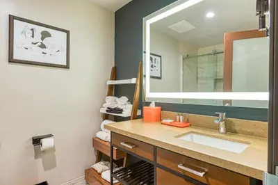 a bathroom with a sink and a large mirror at Hotel Lexen Newhall & Santa Clarita - Near Six Flags Magic Mountain in Santa Clarita