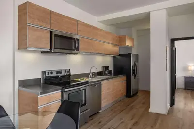a kitchen with stainless steel appliances and wooden cabinets at The Haas, Trademark Collection by Wyndham in Los Angeles