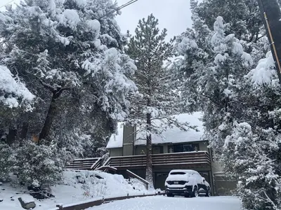 a car parked in front of a house covered in snow at Quail Run Cabin 4,000 Sq.Ft Largest & Most Beautiful House On The Mountain in Pine Mountain Club