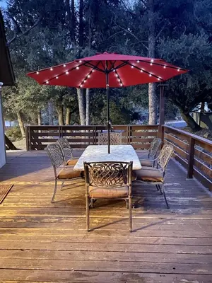 a table and chairs with an umbrella on a deck at Quail Run Cabin 4,000 Sq.Ft Largest & Most Beautiful House On The Mountain in Pine Mountain Club