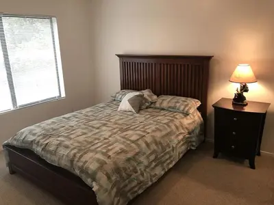 a bedroom with a bed and a lamp and a window at Quail Run Cabin 4,000 Sq.Ft Largest & Most Beautiful House On The Mountain in Pine Mountain Club