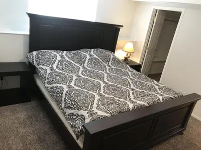 a bedroom with a bed with a black and white comforter at Quail Run Cabin 4,000 Sq.Ft Largest & Most Beautiful House On The Mountain in Pine Mountain Club