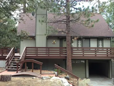 a house with a large deck and a tree at Quail Run Cabin 4,000 Sq.Ft Largest & Most Beautiful House On The Mountain in Pine Mountain Club