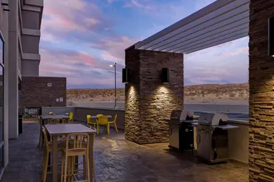 a patio with a bar and tables and chairs at Home2 Suites By Hilton Barstow, Ca in Barstow