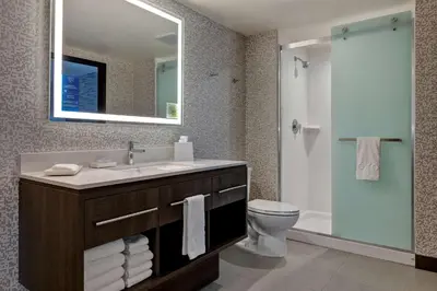 a bathroom with a sink and a toilet and a mirror at Home2 Suites By Hilton Barstow, Ca in Barstow