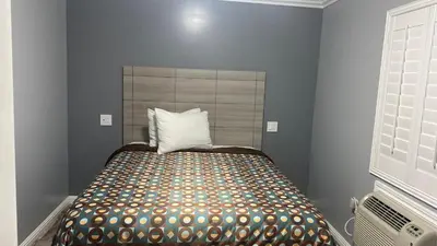 a bedroom with a bed with a pillow on it at La Perla motel in South Gate