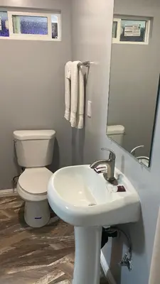 a bathroom with a white sink and a toilet at La Perla motel in South Gate