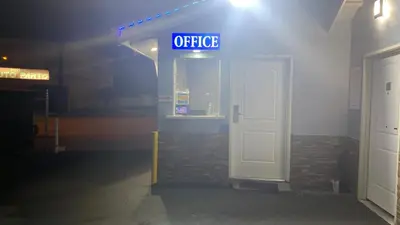 a gas station with a sign that says office at La Perla motel in South Gate