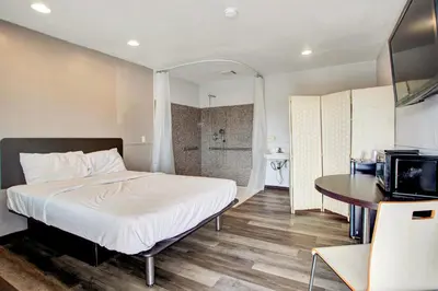 a bedroom with a bed and a table and a television at High Desert Inn in Hesperia