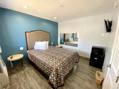 a hotel room with a bed and a mirror at Dixie Motel in Compton