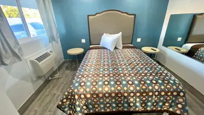 a bedroom with a bed in a room with blue walls at Dixie Motel in Compton