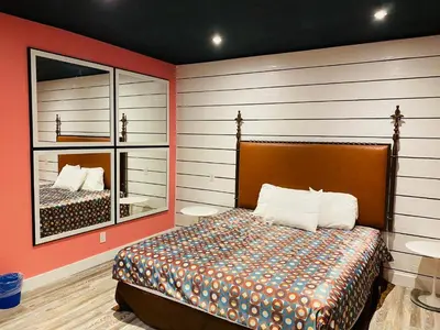 a bedroom with a bed and a large mirror at Casa Valentine Inn - Los Angeles in Los Angeles