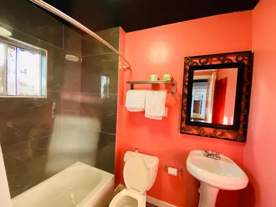 a bathroom with a toilet and a sink and a mirror at Casa Valentine Inn - Los Angeles in Los Angeles