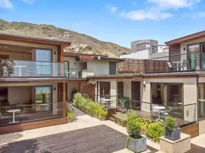 a house with a deck with a mountain in the background at SA Carbon Beach Suites in Malibu