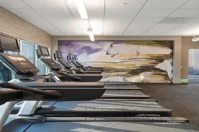 a row of treadmills in a gym with a mural at Courtyard by Marriott Marina del Rey in Los Angeles
