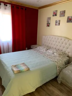 a bedroom with a large white bed with a red curtain at LAX guest house in Inglewood