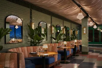 a restaurant with tables and chairs and windows at The Sun Rose West Hollywood in Los Angeles