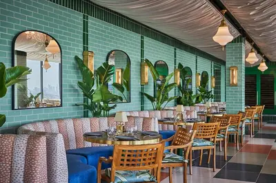 a restaurant with tables and chairs and green tiles at The Sun Rose West Hollywood in Los Angeles
