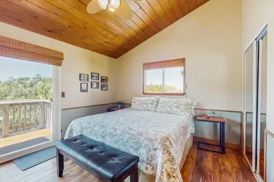a bedroom with a bed and a window at Lake View Magic in Crestline