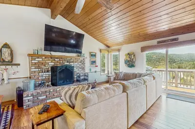 a living room with a couch and a fireplace at Lake View Magic in Crestline