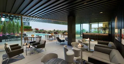 a hotel lobby with tables and chairs and a pool at AKA West Hollywood in Los Angeles
