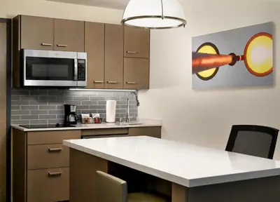 a kitchen with a microwave and a kitchen island at Hyatt House LA - University Medical Center in Los Angeles